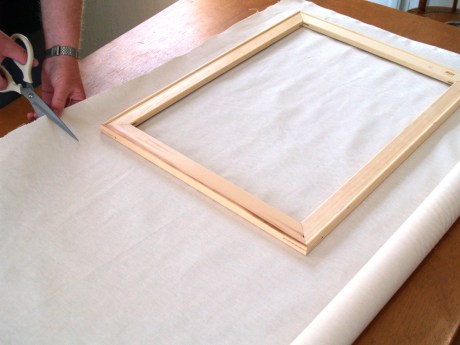 Stretching canvas, measuring to fit the frame. Image courtesy craftsy.com
