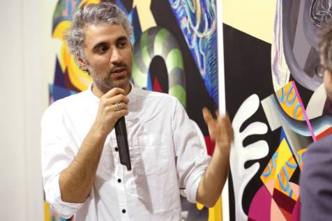 Iraqi artist Athier talks about his work in 'Man of War' exhibition at Edge of Arabia, London. Image courtesy Edge of Arabia.
