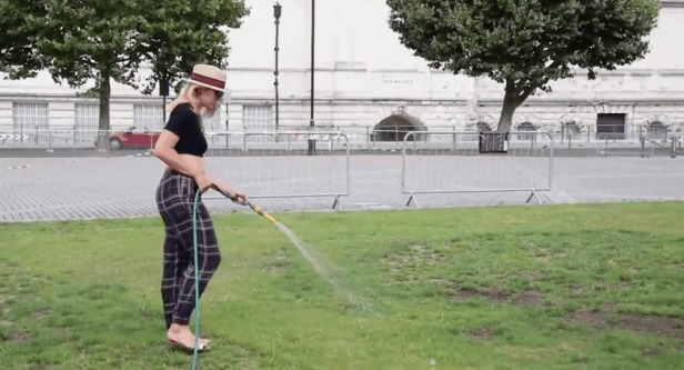 MA Fine Art graduate Denise Ackerl prepares the Parade Ground for the final show, at Chelsea College of Arts, Pimlico, London., with Tate Britain in the background. Image courtesy Chelsea College of Arts.
