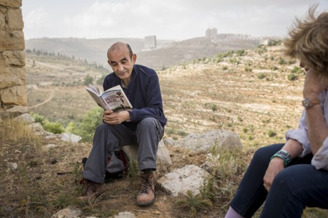 Raja Shehadeh, reads from his book, 'Palestinian Walks', 2008, to artists at the 2014 Palestine Festival of Literature outside Ramallah in June. Photo credit: Rob Stothard/Getty Images. Image courtesy www.wow274.co.uk